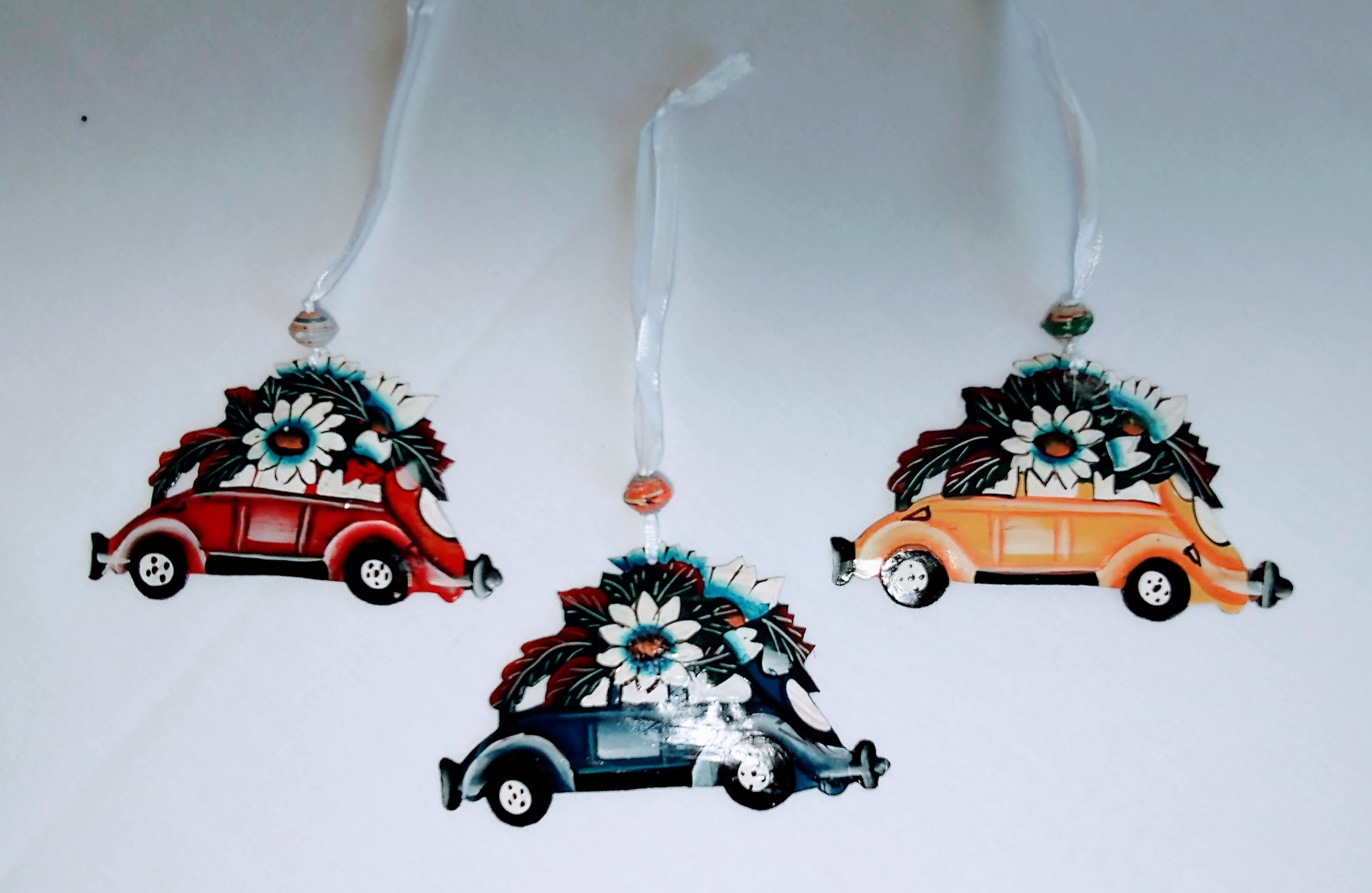 Red, yellow, and blue beetlebug car ornaments with flowers